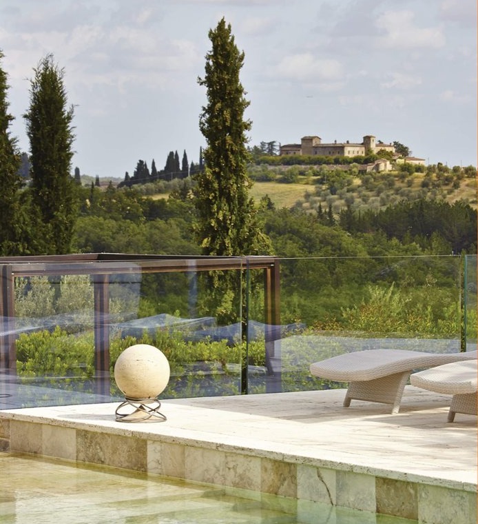 Diffusore scultoreo a bordo piscina con vista sulle colline toscane