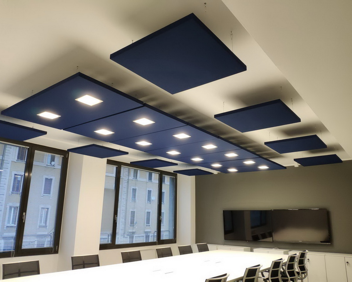 Pannelli acustici geometrici blu con illuminazione a incasso sopra un tavolo riunioni